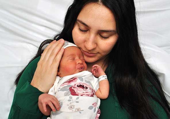 Nadya holding her newborn Elena after a postpartum complication