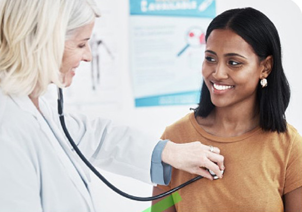 A doctor is listening to the heart of a young woman.