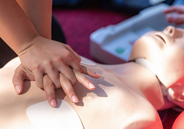 Person practicing CPR on a dummy